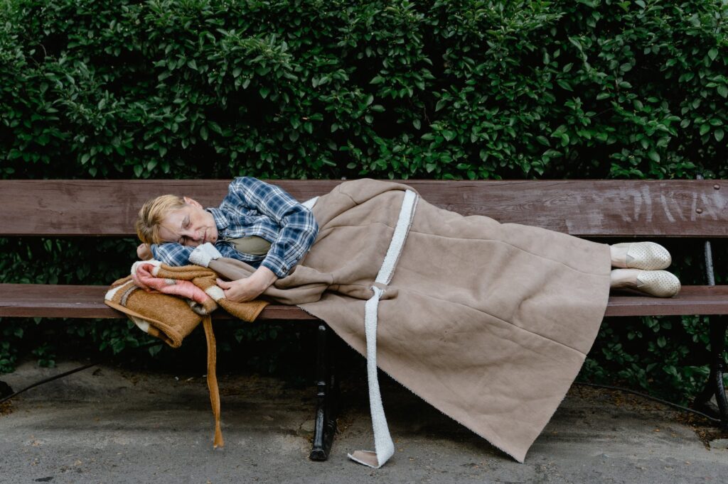 woman sleeping on a wooden bench